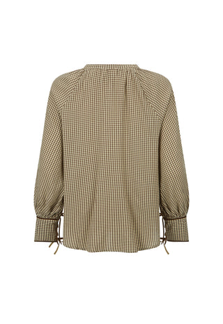  wearing a sheer patterned brown and beige blouse with a matching long skirt